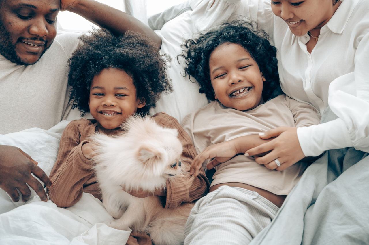 Familia riendo junto a su perro en casa