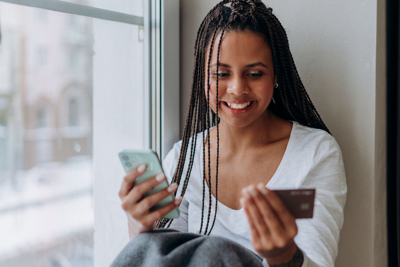 Mujer sonriente pagando su plan desde el celular